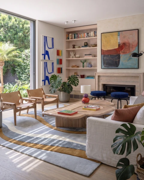 Tapete retangular para sala em tons off-white, cinza e caramelo com design ondulado, em ambiente moderno com móveis de madeira clara e decoração colorida