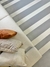 Tapete listrado em veludo granito e off-white com sofá e almofadas.
