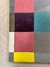 Tapete geométrico com padrão de quadrados coloridos, incluindo cores como granito, cacau, amarelo, natural, tiffany, uva, rosa e verde claro, ideal para quarto infantil.