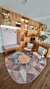 Tapete Optik em sala de estar, com fundo nude rosado e detalhes geométricos em verde menta, granito, bege, rosé gold e creme, rodeado por móveis de madeira e poltronas confortáveis.