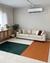 Tapete em cores verde, terracota e off-white em uma sala moderna com sofá bege e almofadas coloridas.