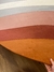 Tapete redondo em tons de terracota, cobre, rosa gold, granito, off-white, verde claro e verde, exibido sobre um piso de madeira, São José.