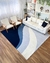 Tapete em tons de azul marinho, azul petróleo, prata e off-white em uma sala moderna com sofá branco e cadeiras de madeira.