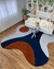 Tapete Libertà orgânico em nylon com bordas assimétricas, nas cores cinza claro, azul marinho, cinza médio e terracota, em uma sala de estar moderna.