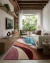 Tapete retangular colorido em sala de estar com tons de rosa, azul, verde e terracota, decorando ambiente moderno com sofá branco, poltrona verde e estante de madeira