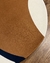 Tapete com bordas orgânicas em veludo nas cores azul marinho, off-white e terracota.
