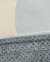 Tapete com bordas orgânicas, estilo Bouclé nas cores cinza, bege e natural, mostrando detalhes da textura e acabamento.
