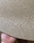 Detalhe do tapete Placas com bordas orgânicas em linho Trento Trigo sendo segurado por uma mão, São José.