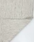 Tapete de fibra natural, feito à mão, nas cores off-white e bege, com detalhe da trama e canto dobrado, Tapetes São José