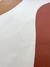 Detalhe do tapete com bordas orgânicas em veludo nas cores cobre, terracota e off-white.