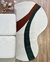 Tapete em nylon com bordas orgânicas nas cores off-white, terracota e verde escuro, colocado em piso de madeira ao lado de móveis.