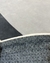 Detalhe do tapete com bordas orgânicas em Bouclé Capri, mostrando a textura e as cores cinza e grafite.