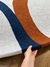 Tapete de nylon com bordas orgânicas em cinza claro, azul marinho e terracota.