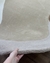 Tapete de nylon com bordas orgânicas em tons bege, trigo e off-white Econyl, sendo segurado por uma mão, São José.