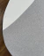 Detalhe do Tapete com bordas orgânicas em linho Nilo nas cores off-white e cinza, sobre piso de madeira.