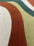 Tapete colorido com design orgânico em tons bege, terracota, verde musgo e verde escuro