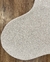 Tapete mesclado com bordas orgânicas em off-white e bege claro, feito de nylon Econyl, sobre piso de madeira.