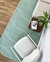 Tapete em nylon verde menta e off-white com bordas orgânicas em uma sala moderna.