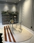 Tapete semi-oval em veludo off-white e terracota em um escritório moderno com mesa de vidro e prateleiras ao fundo.