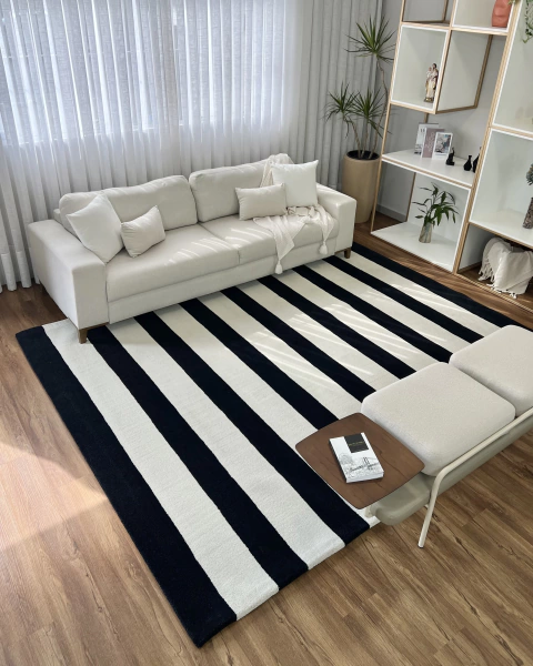 Tapete listrado de nylon em off-white e preto em uma sala de estar moderna.