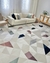 Tapete Optik com fundo off-white e detalhes geométricos em rosé gold, uva, azul marinho, granito, verde claro e verde em uma sala de estar moderna.