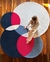 Tapete da Coleção Moon com design geométrico em azul, pink, off-white e prata, com uma pessoa sentada sobre ele.