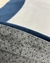 Close-up do tapete com bordas orgânicas em veludo nas cores terracota, bege, azul marinho e granito, destacando a textura e qualidade.
