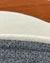 Close-up de um tapete Stone feito de nylon, mostrando as bordas orgânicas em cores off-white e terracota, com parte inferior antiderrapante cinza, São José.