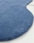 Tapete liso de nylon azul petróleo com bordas orgânicas.