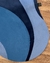 Tapete com bordas orgânicas em veludo nas cores azul marinho, azul profundo e azul celeste, sobre piso de madeira.