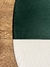 Parte de um tapete com bordas arredondadas nas cores verde e off-white, sobre um piso de madeira.