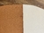 Close-up do tapete Harmonia com bordas arredondadas nas cores terracota e off-white.