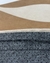 Detalhe do tapete com bordas orgânicas e design Bouclé Atenas nas cores terra, bege e off-white.