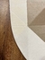 Detalhe do Tapete Optik orgânico com padrão geométrico nas cores off-white, verde claro, granito, rosé gold e bege gold sobre piso de madeira.