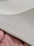 Detalhe do Tapete Kurve® com bordas orgânicas em tons off-white e natural, mostrando a textura e o acabamento do material.