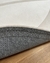 Detalhe do tapete tons off-white e natural, mostrando a parte inferior antiderrapante.