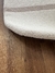 Tapete listrado em nylon nas cores off-white e bege claro sobre piso de madeira.
