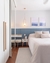 Quarto moderno com tapete quadrado linho mesclado off-white ao lado de uma cama de casal e decoração minimalista.