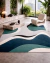 Tapete retangular para sala nas cores verde, preto, off-white, cinza e azul da Coleção Wave, com design moderno e abstrato, em ambiente contemporâneo com plantas e móveis sofisticados.