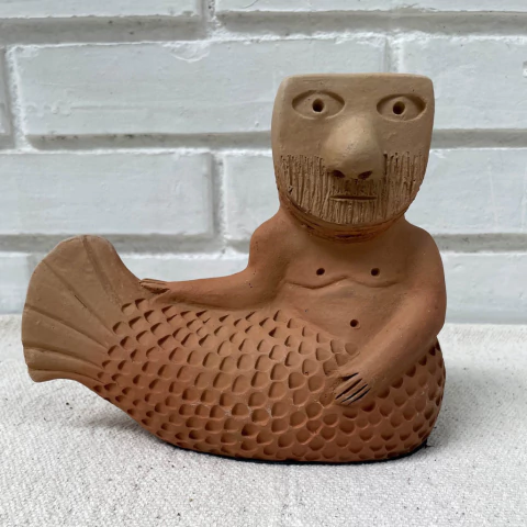 Estatueta de cerâmica representando o Sereio * Mano de Baé, com corpo de peixe e rosto humano, destacando detalhes faciais e escamas.