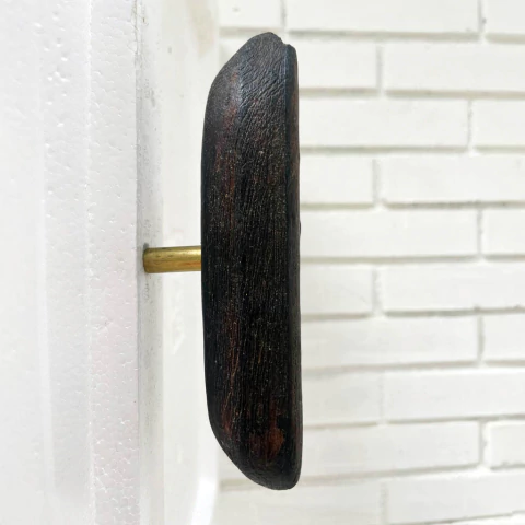 Cabideiro Banana da coleção Podre de Chique, design de Marlon Carvalho, montado em parede branca.