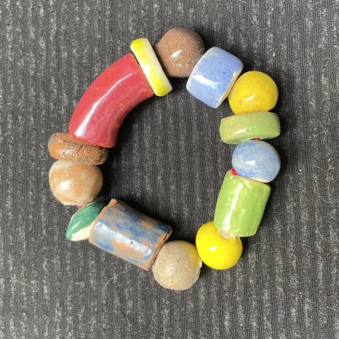 Pulseira de cerâmica colorida com diversos formatos e texturas, destacando-se por suas cores vibrantes.