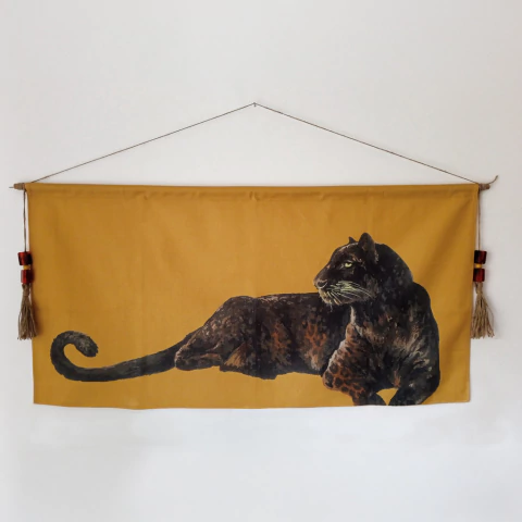Pintura em tecido tipo bandeira com imagem detalhada de uma pantera deitada em fundo amarelo mostarda