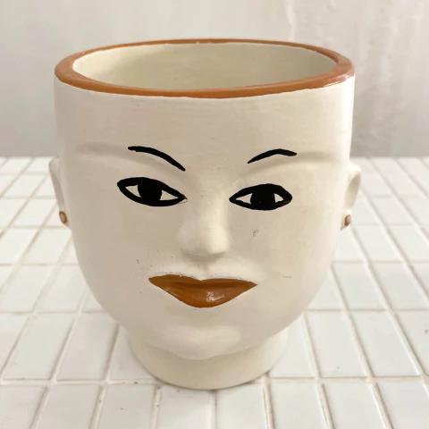 Vaso decorativo em forma de rosto, com detalhes em preto e laranja, criado por Sergina Xavier.