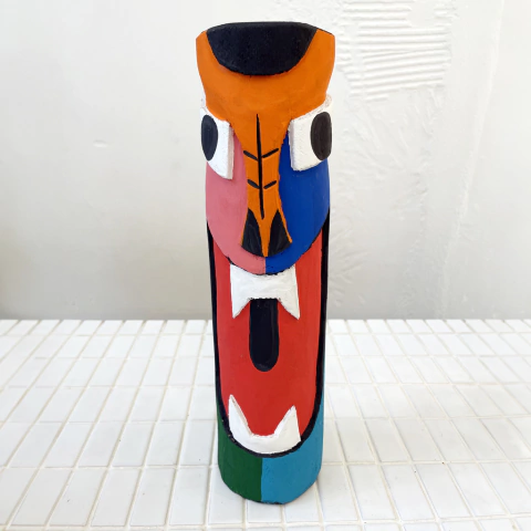 Carranca colorida com rosto de animal, exibindo detalhes em vermelho, azul e laranja.