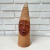 Escultura de cerâmica em formato de figura humana com uma face esculpida e um chapéu pontudo, feita por Getúlio Maurício.