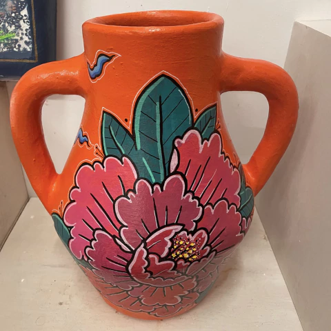 Vaso de cerâmica laranja com duas alças, decorado com pintura de flores rosas e folhas verdes