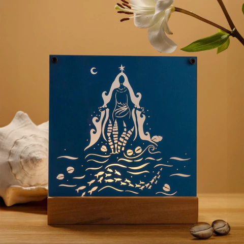 Iluminária decorativa azul com a representação de Iemanjá rodeada por peixes e conchas.