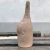 Escultura em cerâmica de um boto cor de rosa estilizado em tom marrom com acabamento fosco