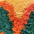 Almofada colorida com texturas em camadas de tecidos nas cores laranja, amarelo e verde.